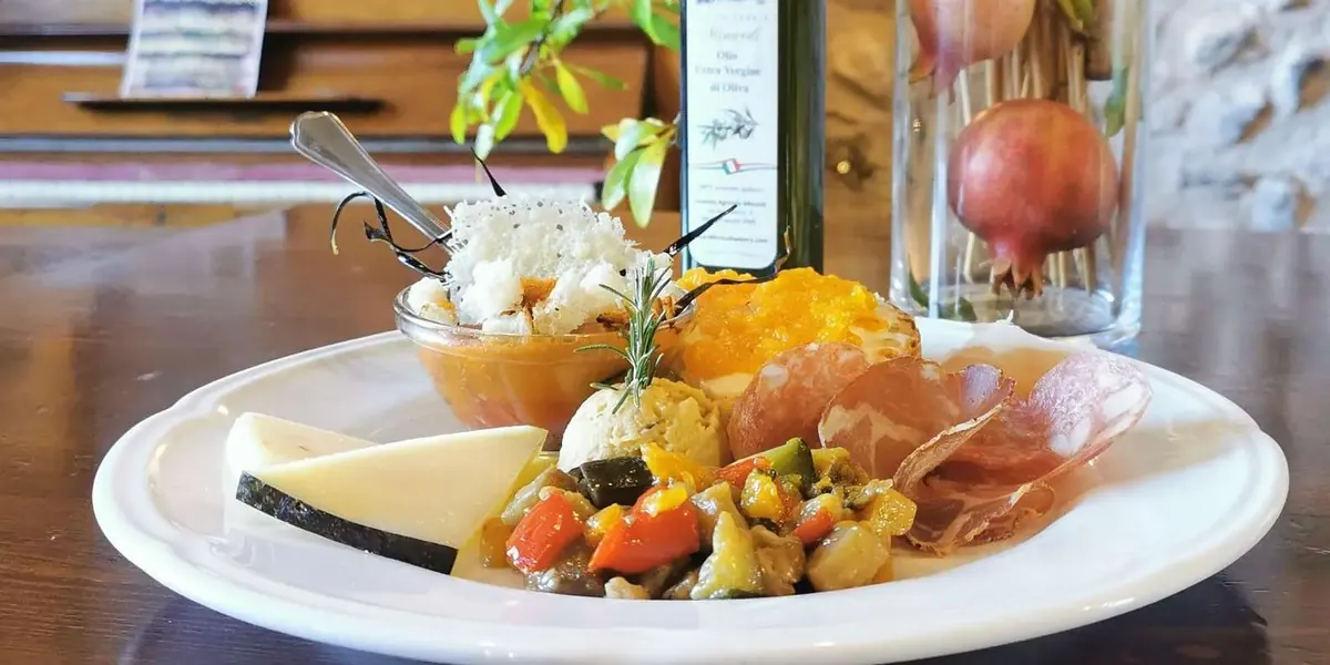 A plated farmhouse lunch served beside a glass of wine